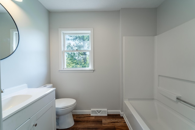 bathroom featuring baseboards, visible vents, toilet, wood finished floors, and vanity