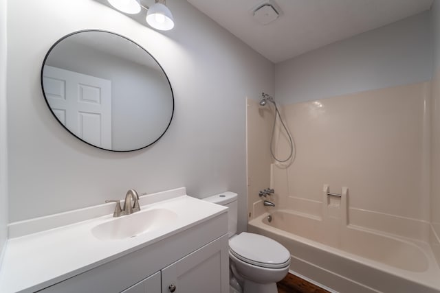 full bathroom with tub / shower combination, vanity, toilet, and wood-type flooring