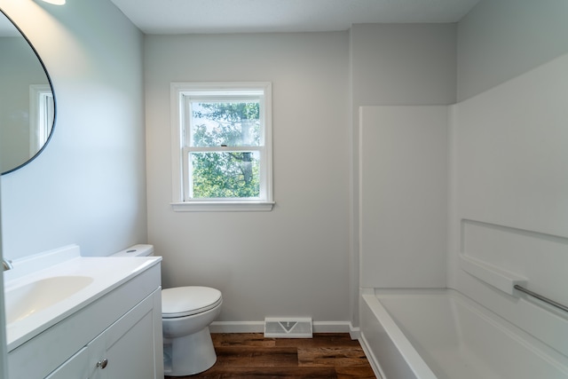 full bathroom with hardwood / wood-style flooring, tub / shower combination, toilet, and vanity