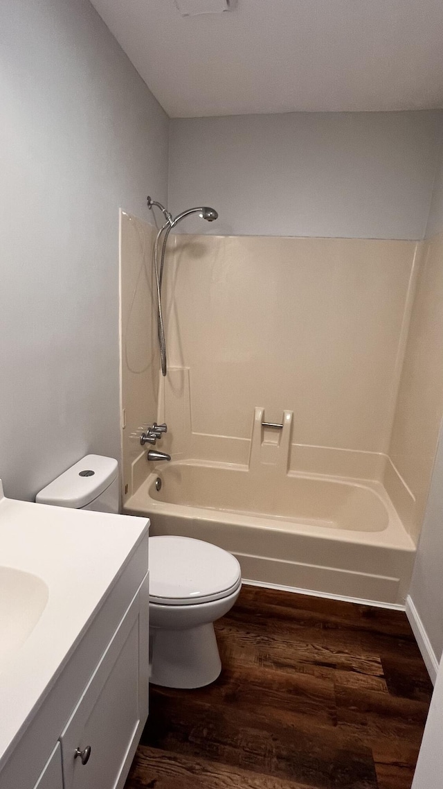 bathroom with vanity, bathing tub / shower combination, wood finished floors, and toilet