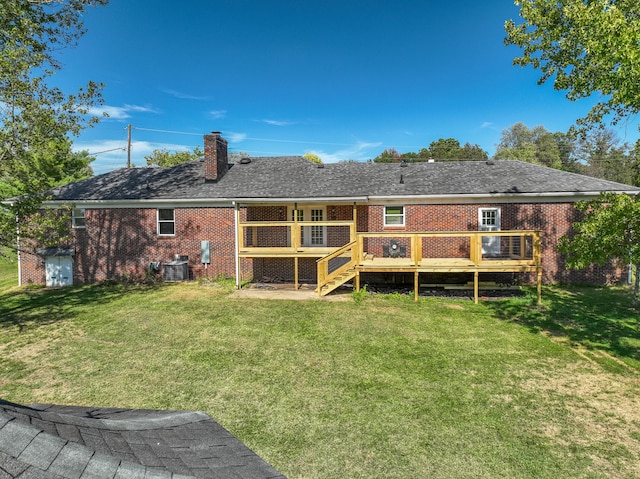 rear view of house featuring a wooden deck, a lawn, and central AC