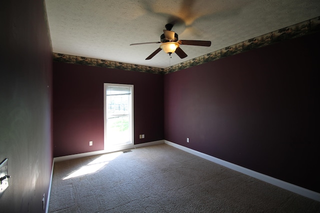 carpeted spare room with ceiling fan and a textured ceiling