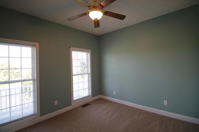 carpeted spare room with ceiling fan