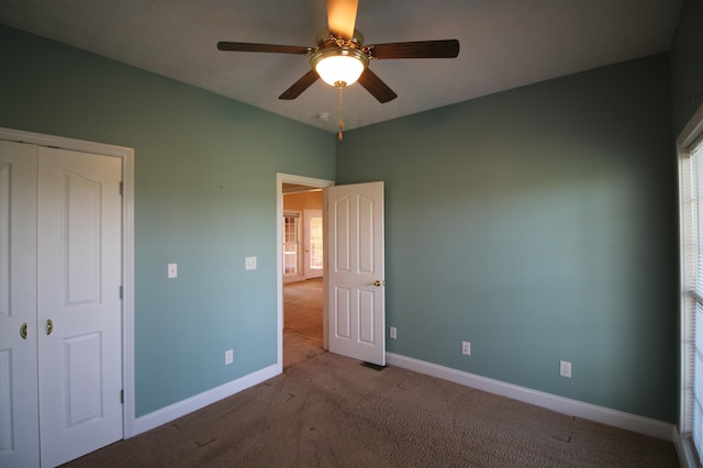 unfurnished bedroom featuring ceiling fan, a closet, and light carpet