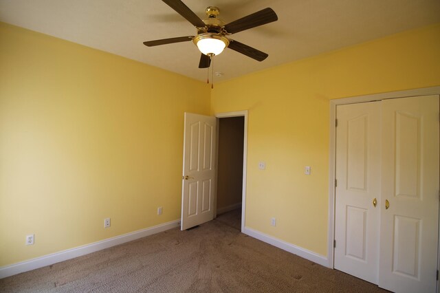 unfurnished bedroom featuring light carpet, ceiling fan, and a closet