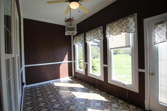 unfurnished sunroom with ceiling fan