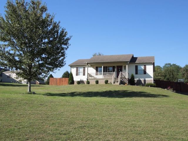 ranch-style house featuring a porch, a front lawn, and fence