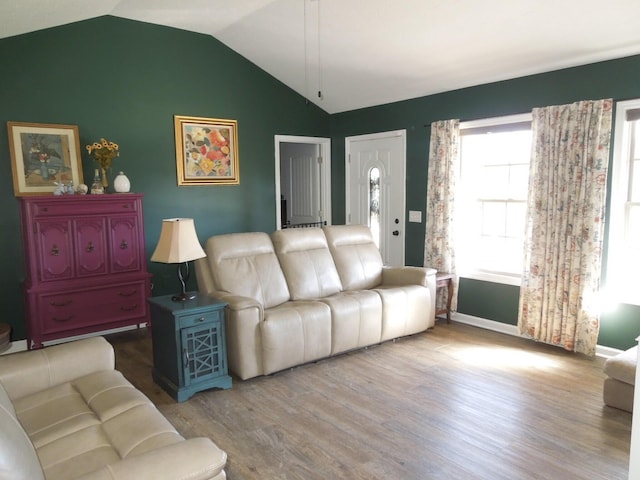 living room with lofted ceiling, baseboards, and wood finished floors