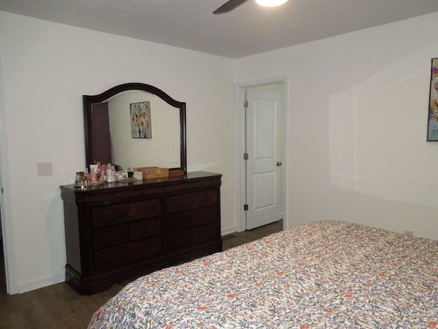 bedroom with dark wood-style floors, ceiling fan, and baseboards