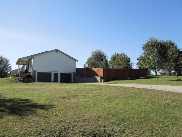 view of yard featuring a garage, driveway, and fence