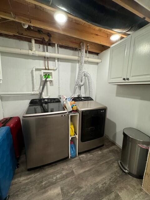 clothes washing area featuring washer and dryer and cabinet space