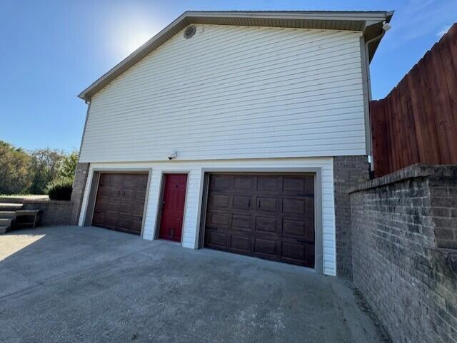 garage with driveway and fence