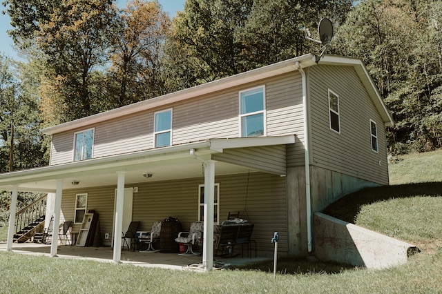 back of property featuring a yard and a patio area