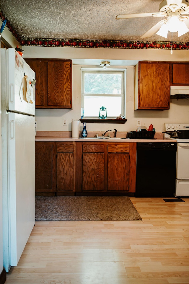 kitchen with light hardwood / wood-style flooring, white appliances, a textured ceiling, and ceiling fan