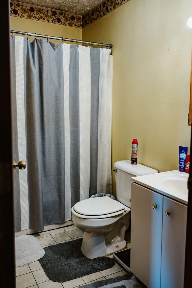 bathroom with curtained shower, vanity, toilet, and tile patterned floors