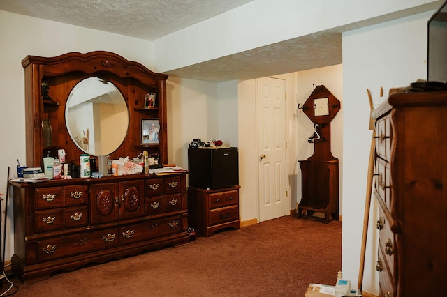 bedroom featuring a textured ceiling and carpet flooring