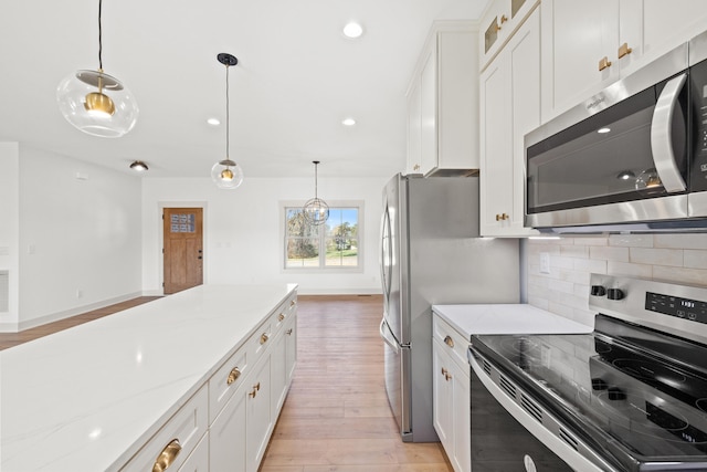 kitchen featuring stainless steel appliances, light stone countertops, light hardwood / wood-style flooring, and white cabinets