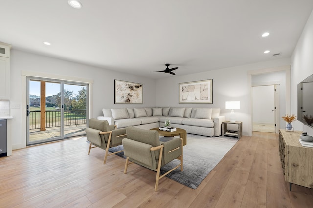 living room featuring ceiling fan and light hardwood / wood-style flooring