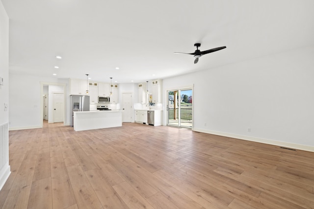 unfurnished living room featuring light hardwood / wood-style floors and ceiling fan