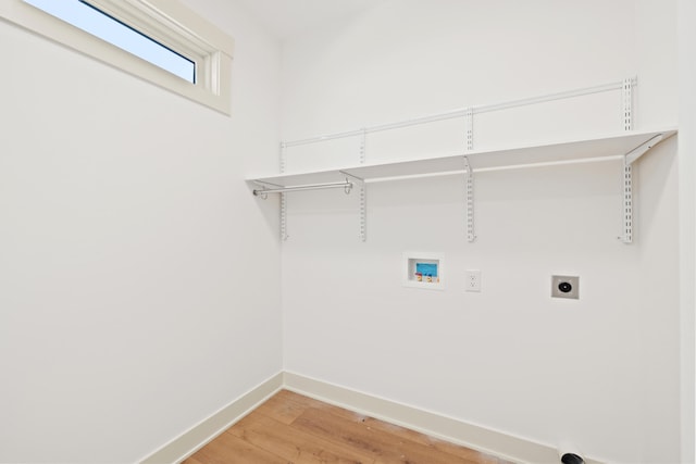 washroom with hookup for an electric dryer, hookup for a washing machine, and wood-type flooring