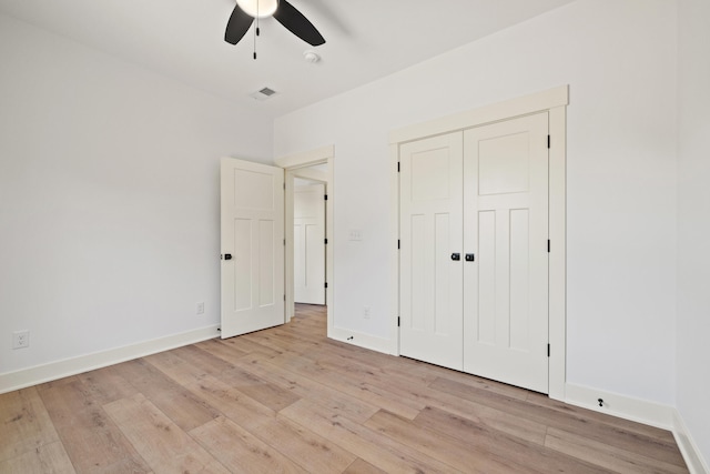 unfurnished bedroom with light hardwood / wood-style flooring, a closet, and ceiling fan