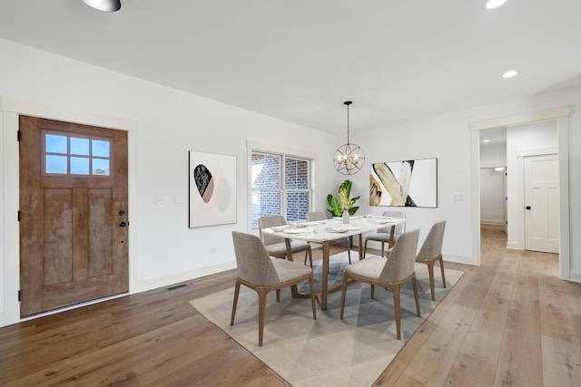 dining room with a chandelier and light hardwood / wood-style floors