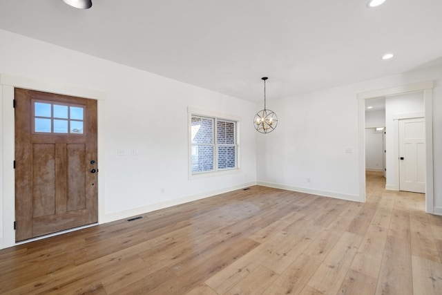 entrance foyer featuring light hardwood / wood-style flooring and an inviting chandelier