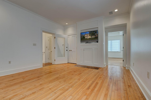 unfurnished living room with light hardwood / wood-style flooring and ornamental molding