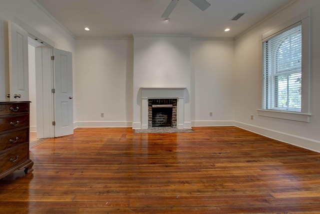 unfurnished living room with a brick fireplace, ceiling fan, hardwood / wood-style floors, and ornamental molding