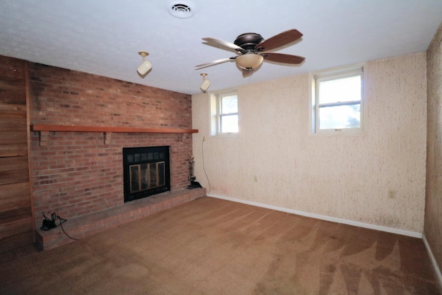 unfurnished living room featuring a ceiling fan, visible vents, a brick fireplace, carpet floors, and baseboards