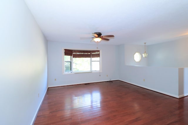 empty room with ceiling fan and dark hardwood / wood-style flooring