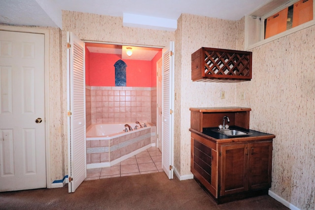 bathroom with tiled tub, vanity, and tile patterned floors