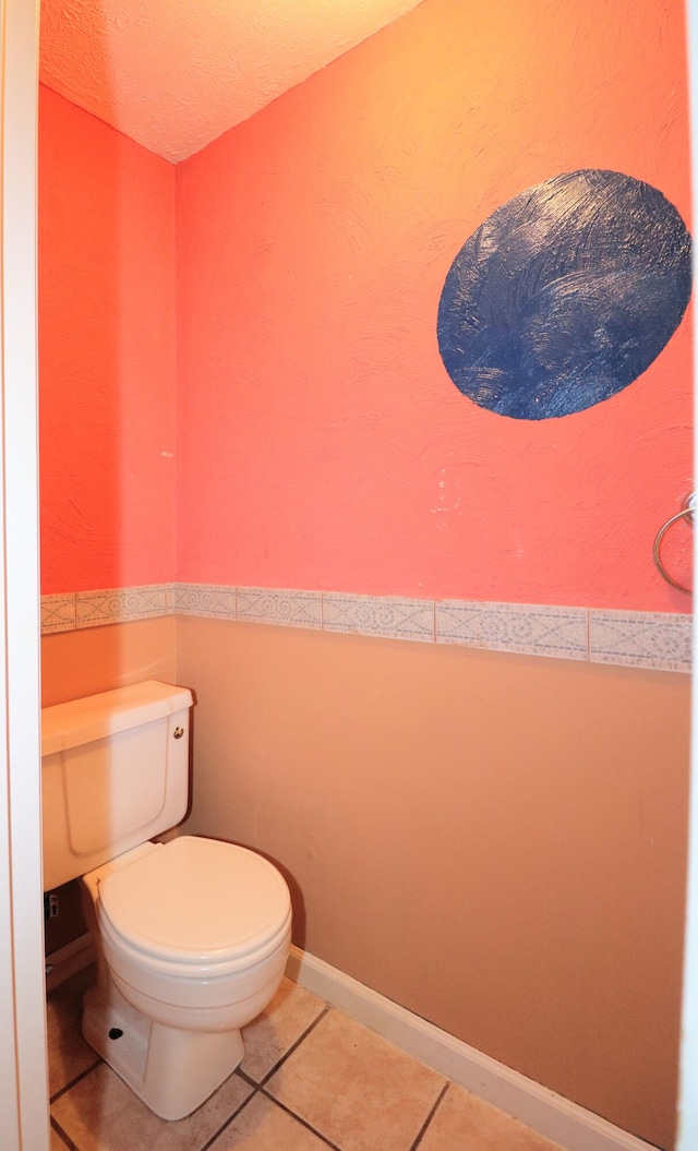 bathroom featuring a textured ceiling, tile patterned flooring, and toilet