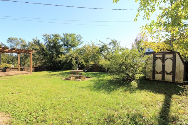 view of yard featuring fence, a storage unit, an outdoor structure, and a pergola