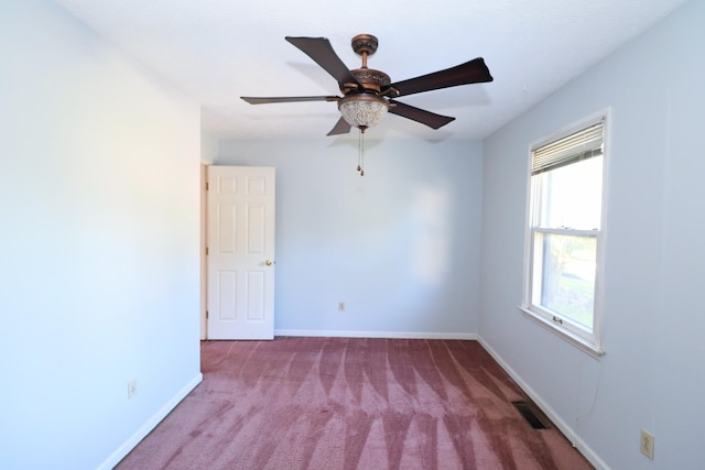spare room featuring carpet flooring, baseboards, visible vents, and ceiling fan