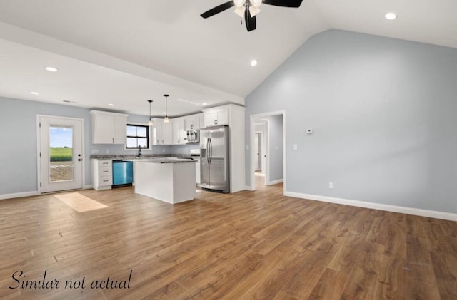 kitchen with stainless steel appliances, open floor plan, and white cabinetry