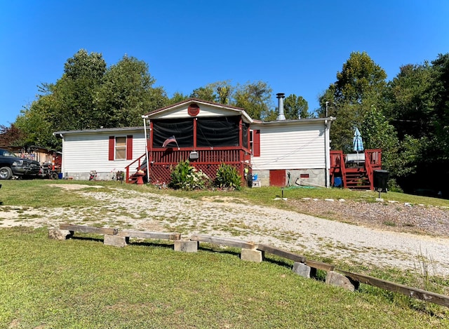 manufactured / mobile home with a front yard and a wooden deck