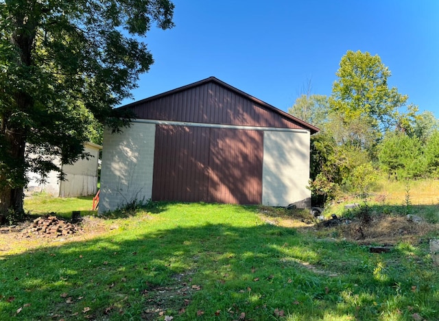 view of side of home with an outbuilding and a yard