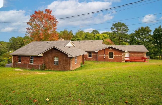 back of house with a wooden deck and a lawn