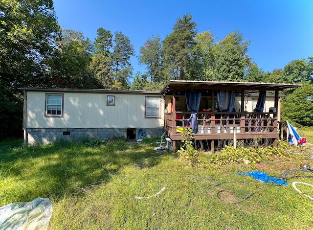 rear view of property featuring a deck and a lawn