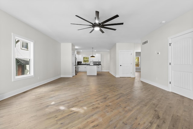 323 Conway St, Frankfort, KY 40601 - unfurnished living room featuring light wood-type flooring, visible vents, baseboards, and ceiling fan