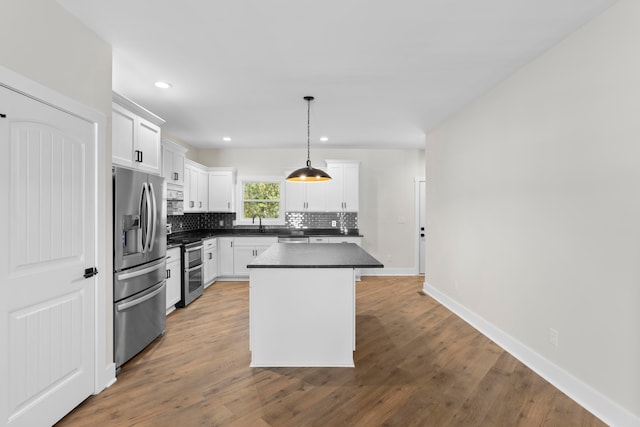 kitchen with hanging light fixtures, a kitchen island, wood-type flooring, white cabinetry, and stainless steel appliances