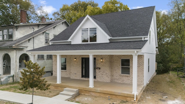 323 Conway St, Frankfort, KY 40601 - view of front facade with a chimney, board and batten siding, brick siding, a porch, and roof with shingles