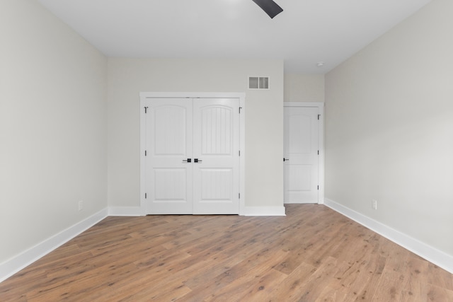 unfurnished bedroom featuring ceiling fan, a closet, and light hardwood / wood-style floors