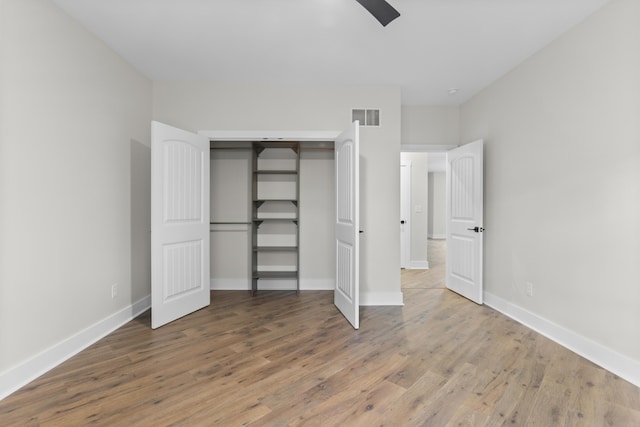 323 Conway St, Frankfort, KY 40601 - unfurnished bedroom with baseboards, wood finished floors, visible vents, and a closet