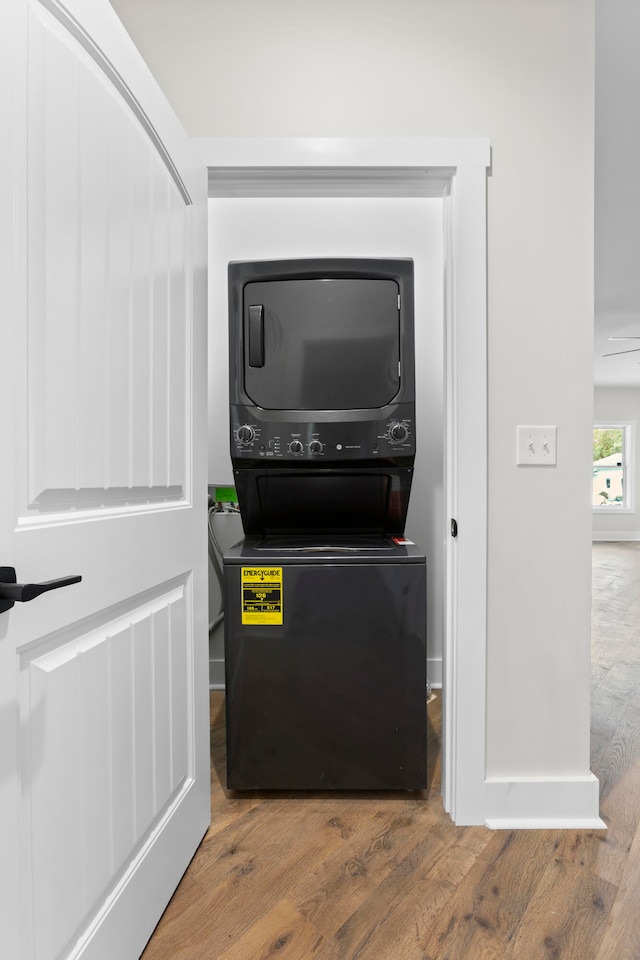 interior space with wood-type flooring and stacked washer / dryer