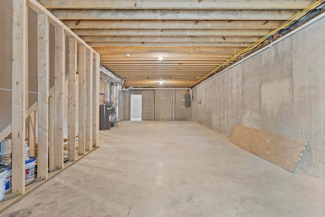 basement with electric panel and electric water heater