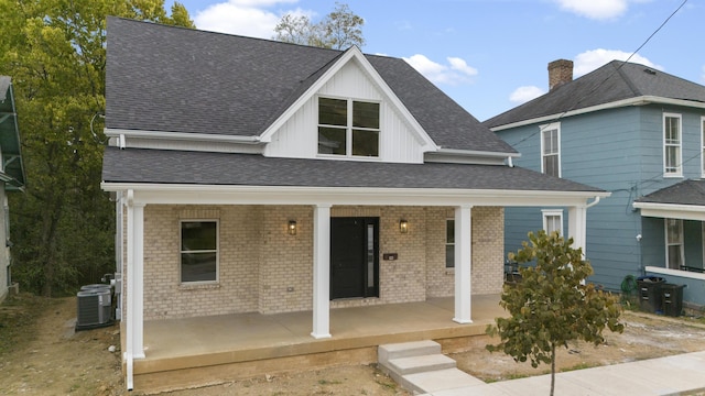 323 Conway St, Frankfort, KY 40601 - view of front of home with central AC unit, roof with shingles, board and batten siding, a porch, and brick siding
