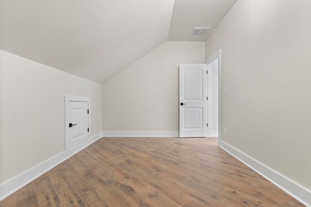 bonus room with lofted ceiling and wood-type flooring