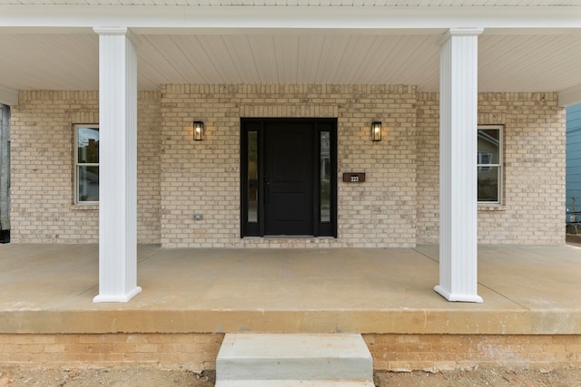 view of exterior entry featuring covered porch